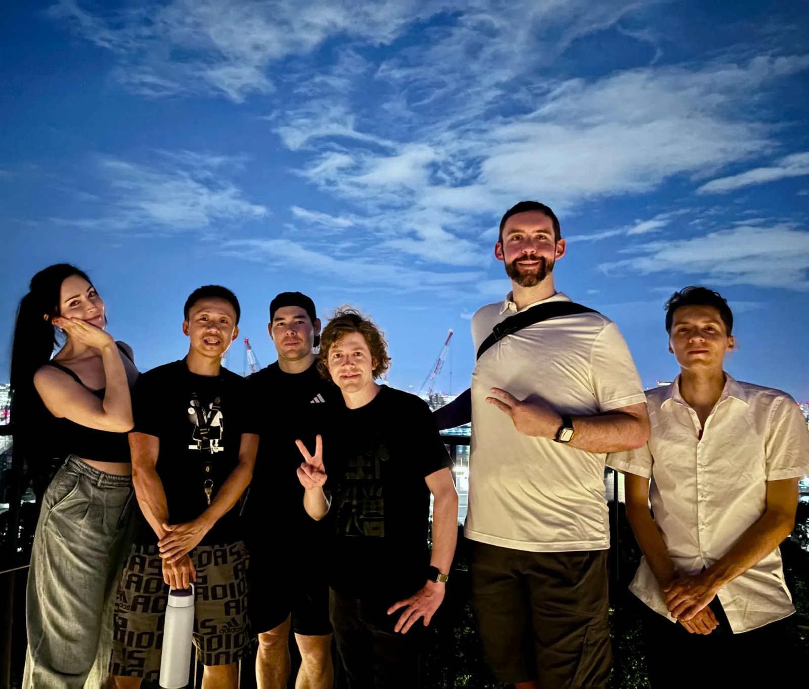 Members together by the bay at dusk in Fukuoka