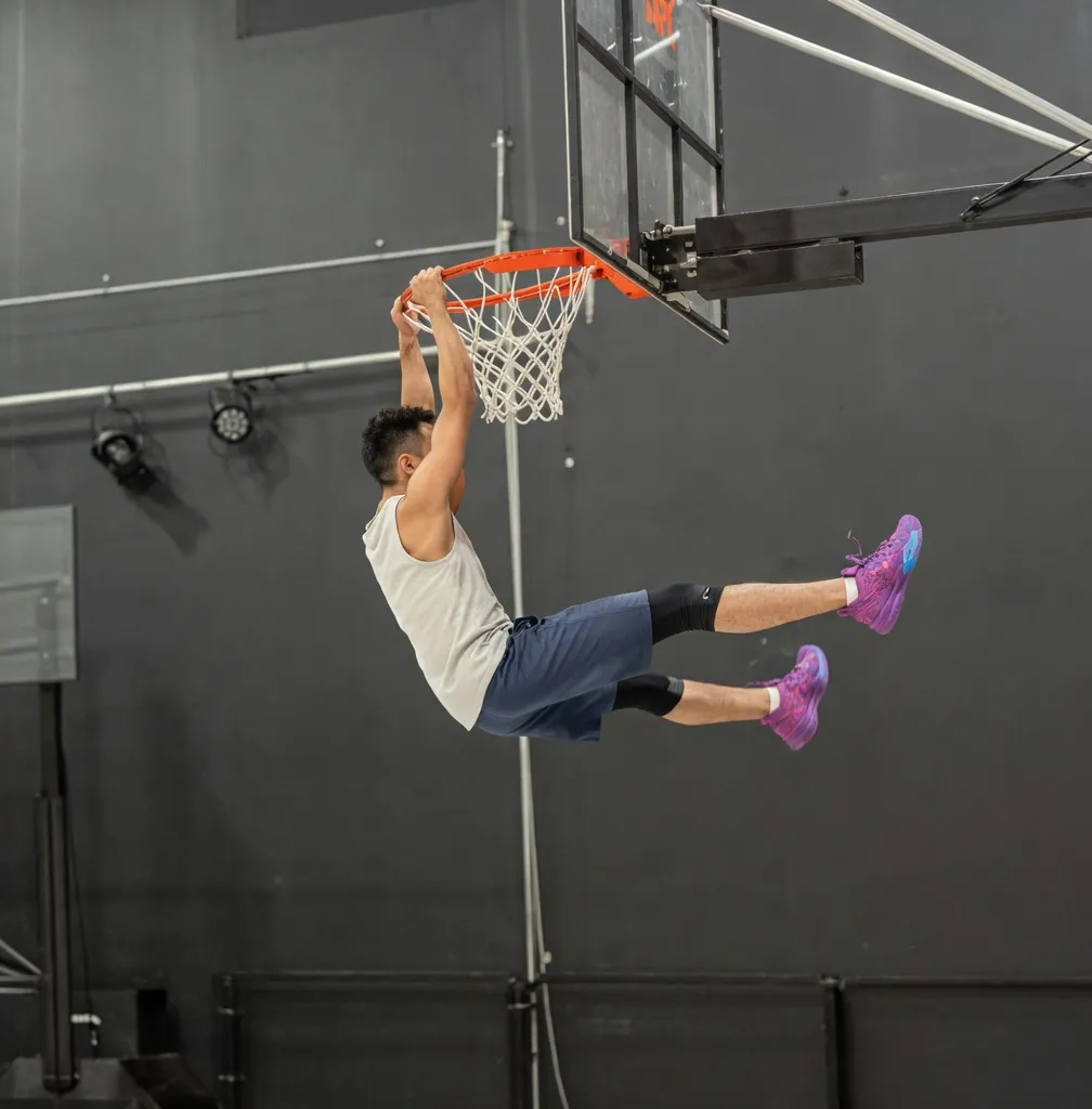 Yoshi Takada hanging from the rim after a dunk